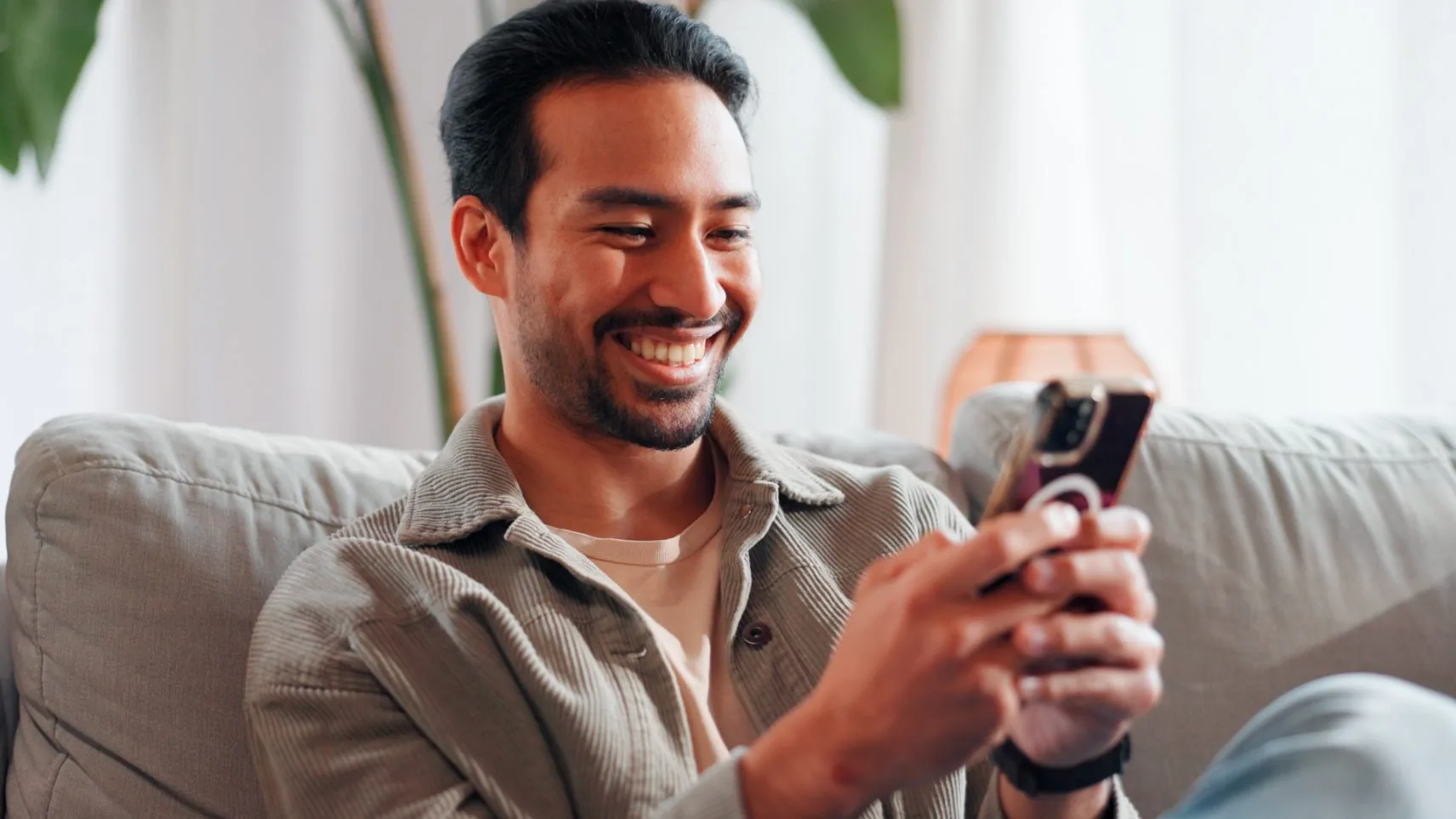Homem sorrindo enquanto usa o aplicativo no smartphone